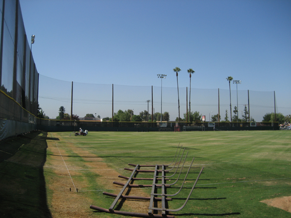 Judge Netting Barrier Specialists: A baseball field with a boundary netting fence for ball containment.