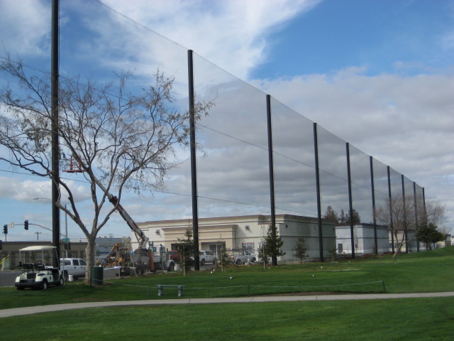 Judge Netting Barrier Specialists: The grass is green on a golf course with netting barriers.
