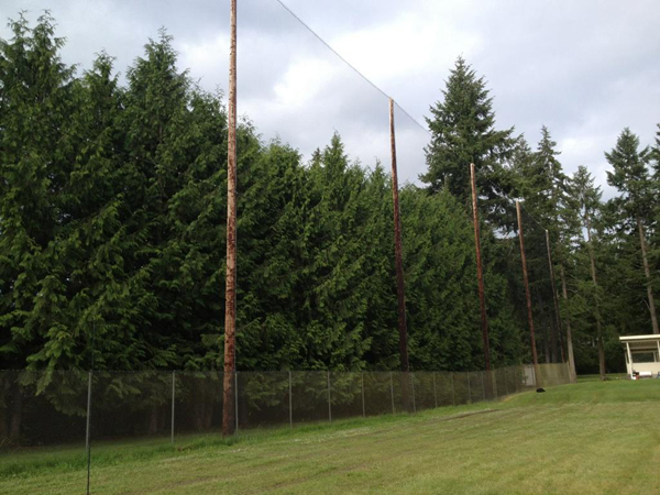 Judge Netting Barrier Specialists: A driving range with a lot of trees and golf course netting barrier.