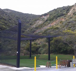 Judge Netting Barrier Specialists: A sports field netting barrier enclosing a seating area.