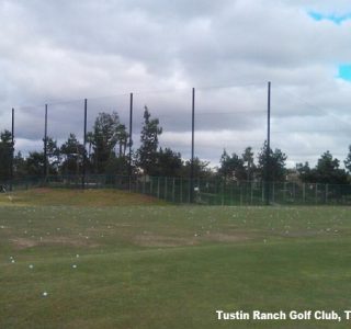 A golf driving range with scattered balls, high Golf Netting, and trees at Tustin Ranch Golf Club in Tustin, California under a cloudy sky.
