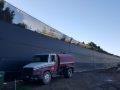 Judge Netting Barrier Specialists: A truck is parked in front of a industrial waste landfill barrier.